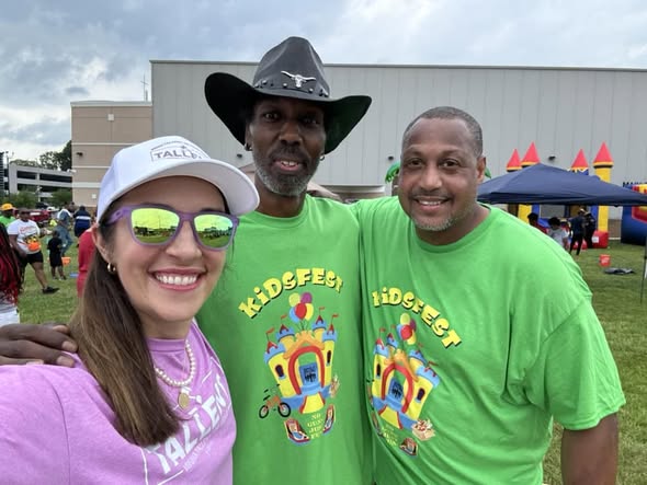 KidsFest volunteers in green shirts posing for a selfie