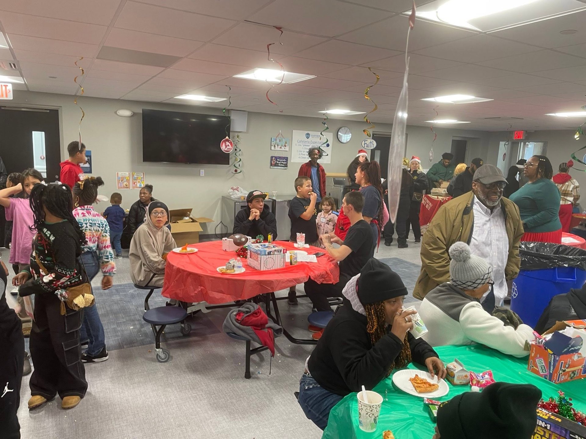 Families and youth gathered around festive tables in the cafeteria during Brothas Inc. Jingle Jam 2025