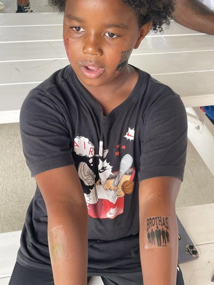 Kid showing off a Brothas Inc. temporary tattoo on his arm at 3rd KidsFest