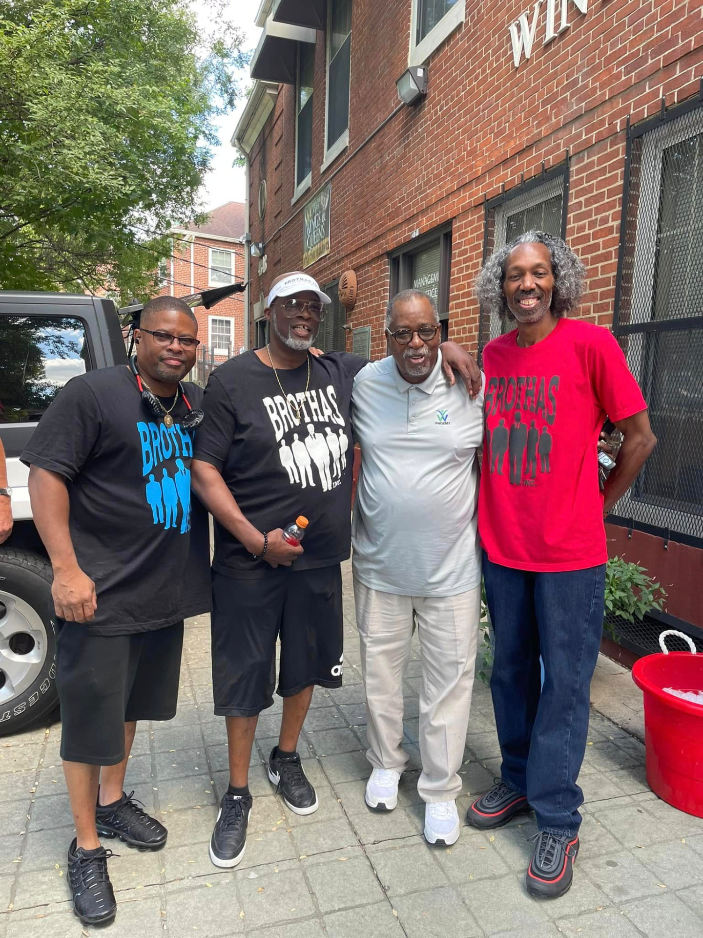 Four Brothas Inc. members standing arm in arm outside at the 2024 Backpack Giveaway
