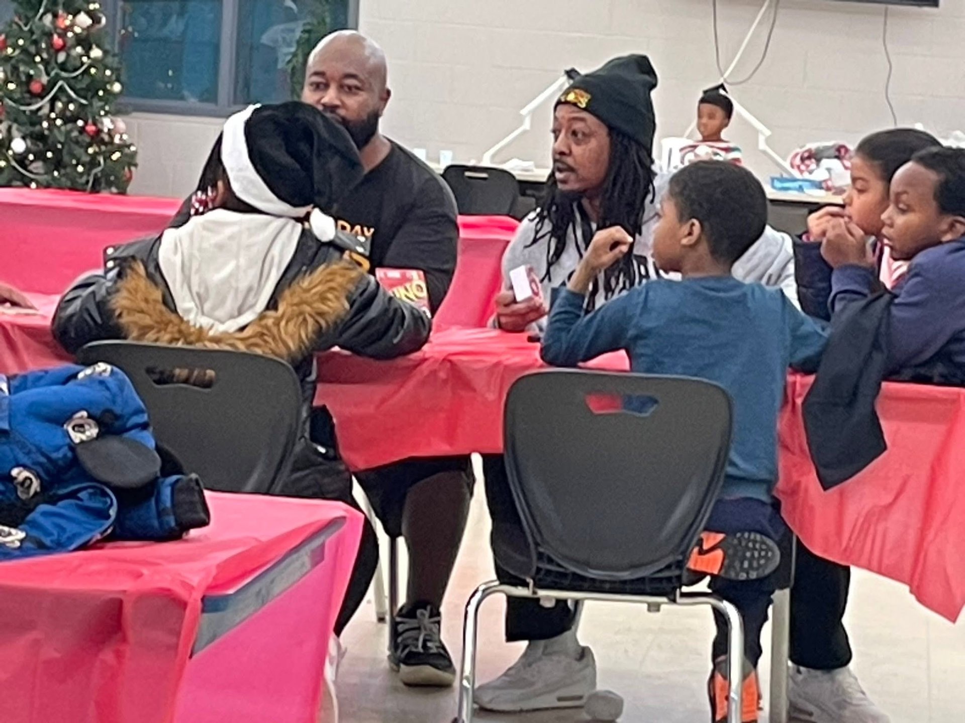 Brothas Inc. mentors sitting and talking with youth at the craft tables during Jingle Jam 2025