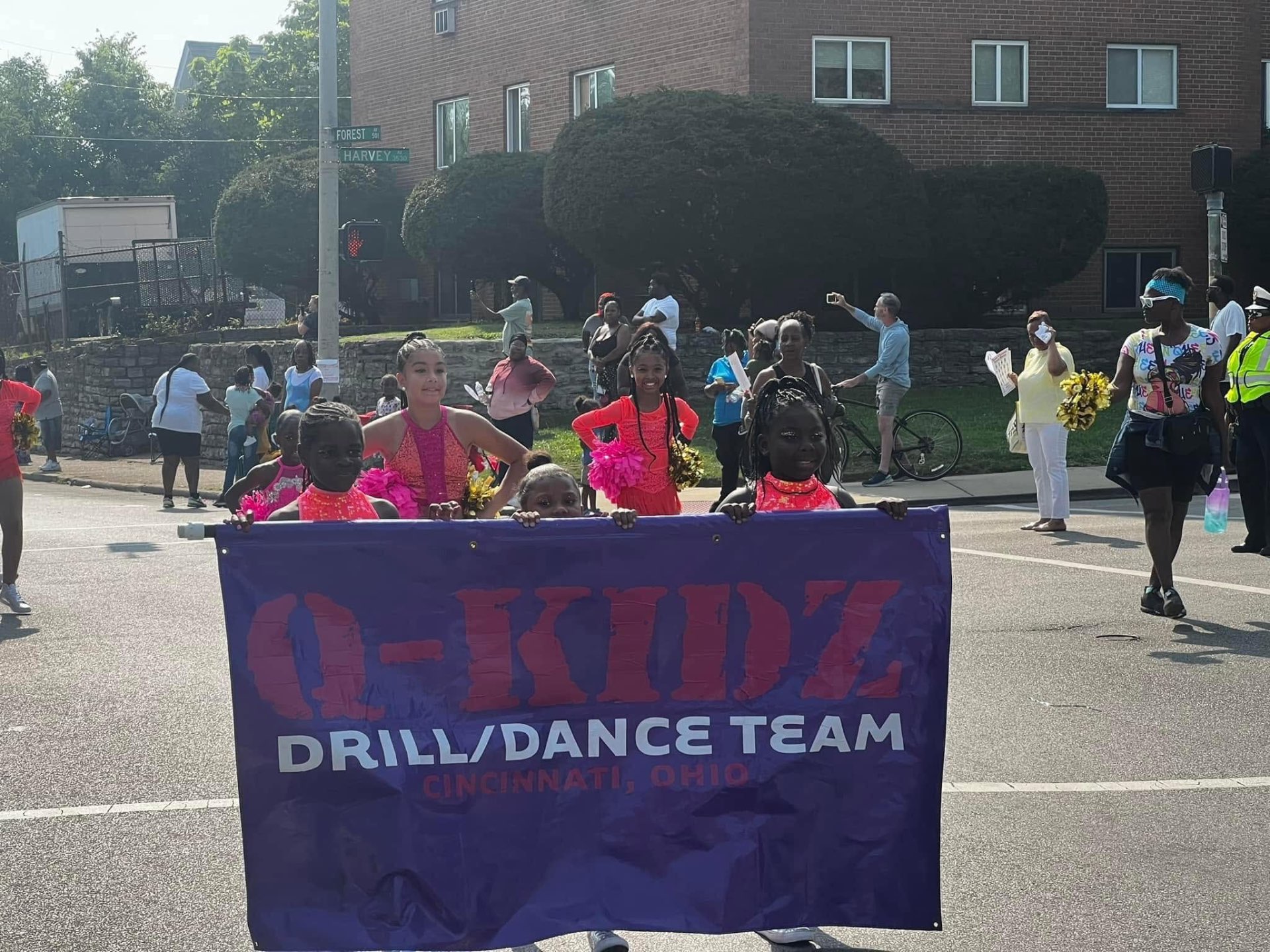 Q-Kidz Drill and Dance Team of Cincinnati posing with their banner at the Black Family Reunion Parade