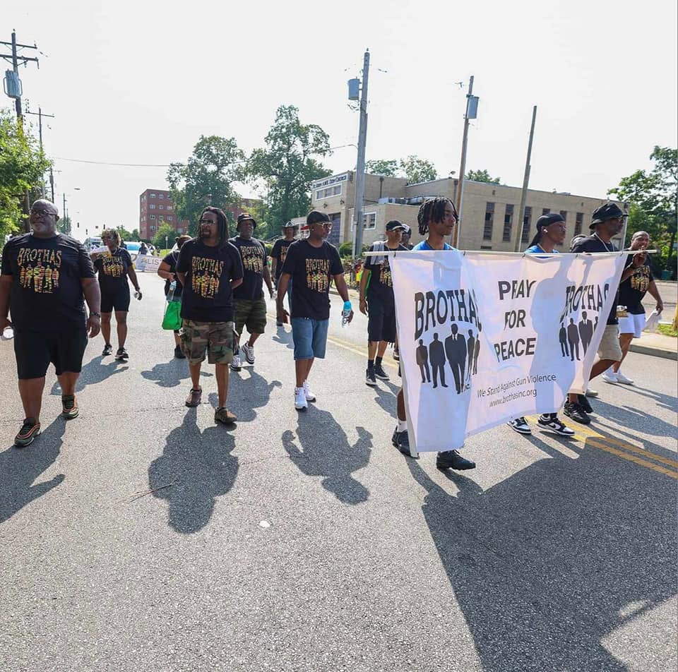 Brothas Inc. mentors marching down a Cincinnati street carrying the Pray For Peace banner during Black Family Reunion 2024