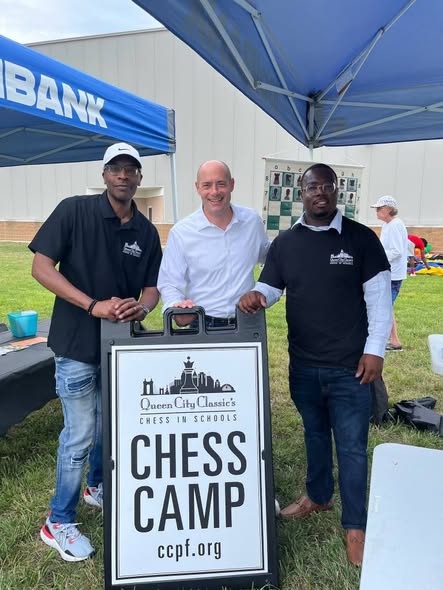 Three men at Queen City Classic Chess Camp booth at 2nd KidsFest
