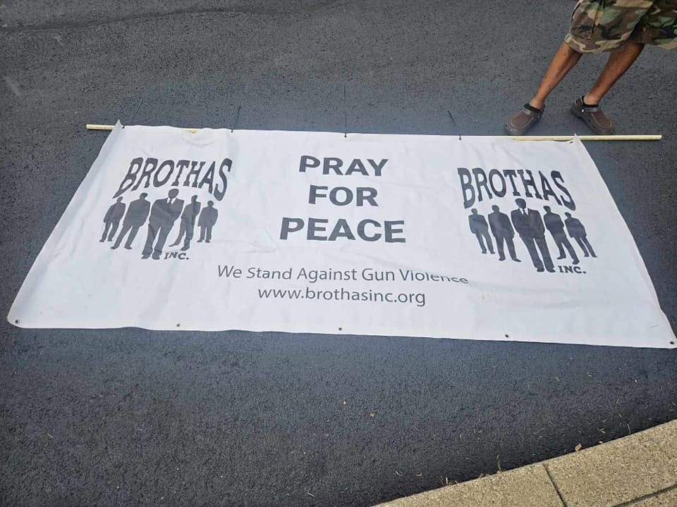 Brothas Inc. Pray For Peace banner laid out on the street before the Black Family Reunion 2024 march against gun violence