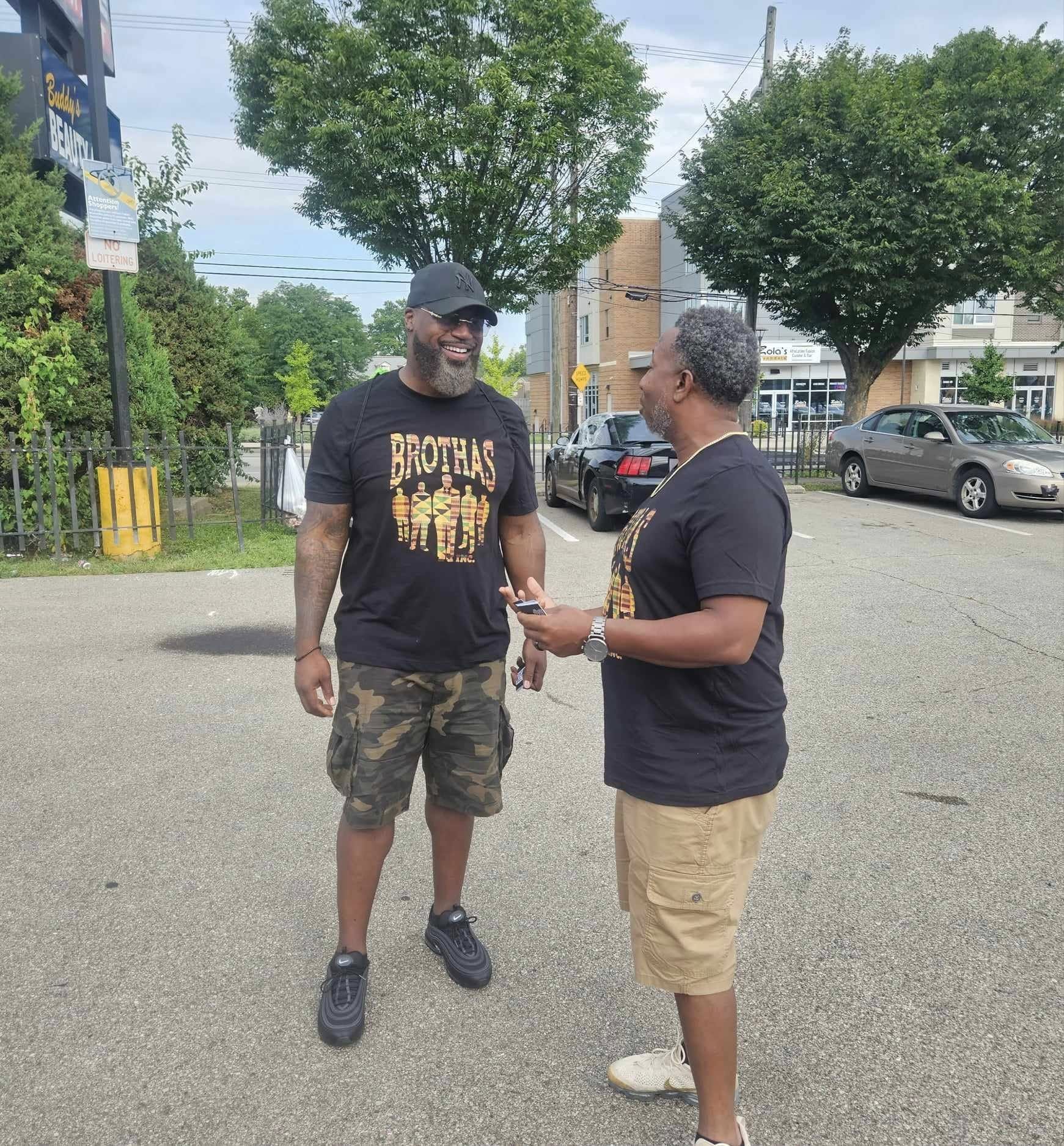 Two Brothas Inc. mentors in kente-print shirts sharing a conversation at the Black Family Reunion 2024