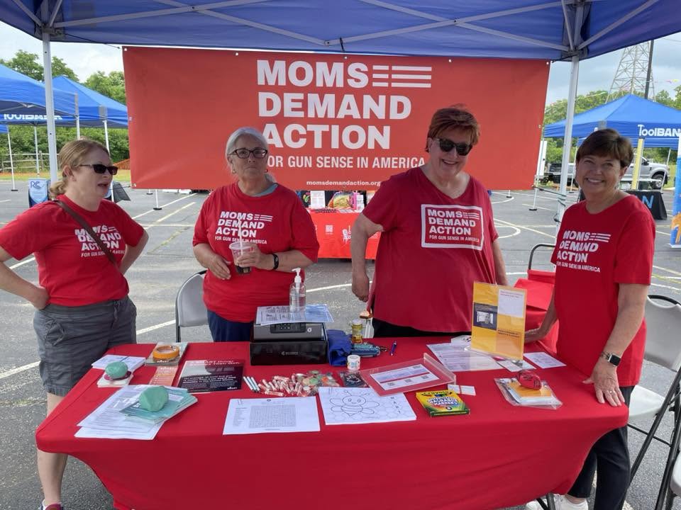 Moms Demand Action volunteers behind their gun-sense resource table at 3rd KidsFest