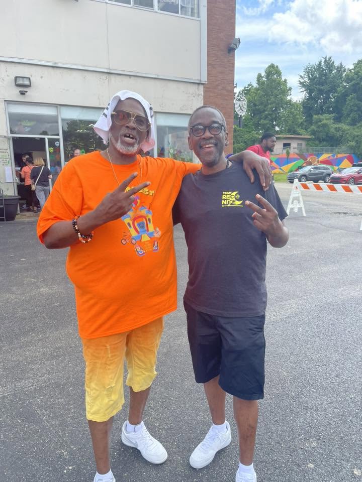 Two mentors in KidsFest and Team Reunite shirts throwing peace signs at 3rd KidsFest
