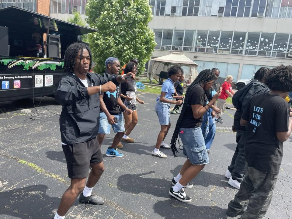 Youth performing a group dance routine beside the Jake Sweeney mobile stage at 3rd KidsFest