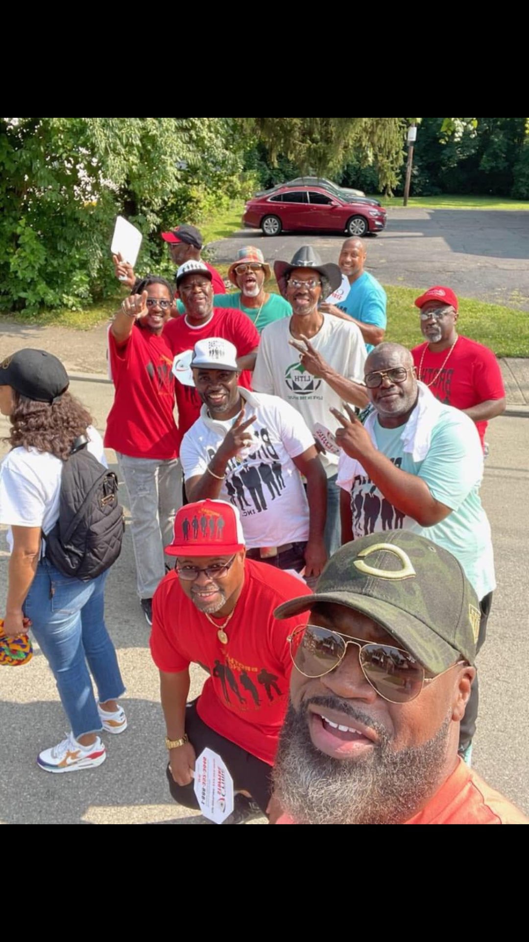 Overhead selfie of the Brothas Inc. squad throwing peace signs before the Black Family Reunion Parade