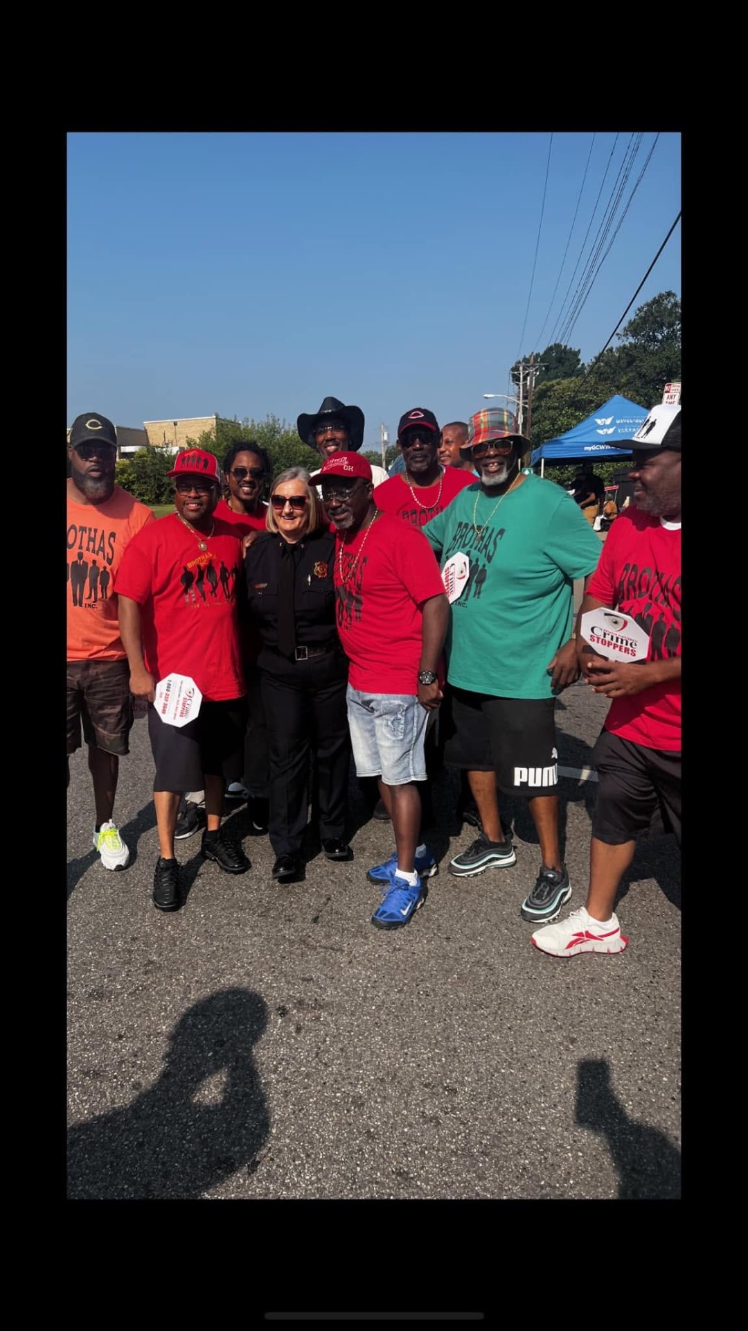 Brothas Inc. team posing with a Hamilton County Sheriff deputy at the Black Family Reunion Parade
