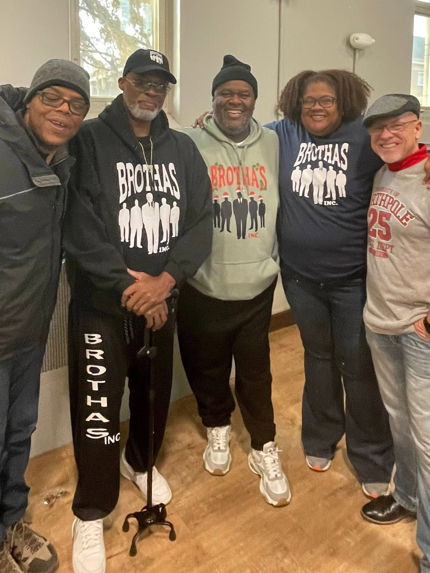 Five Brothas Inc. leaders and volunteers in matching Brothas Inc. hoodies and gear posing together at Jingle Jam 2025