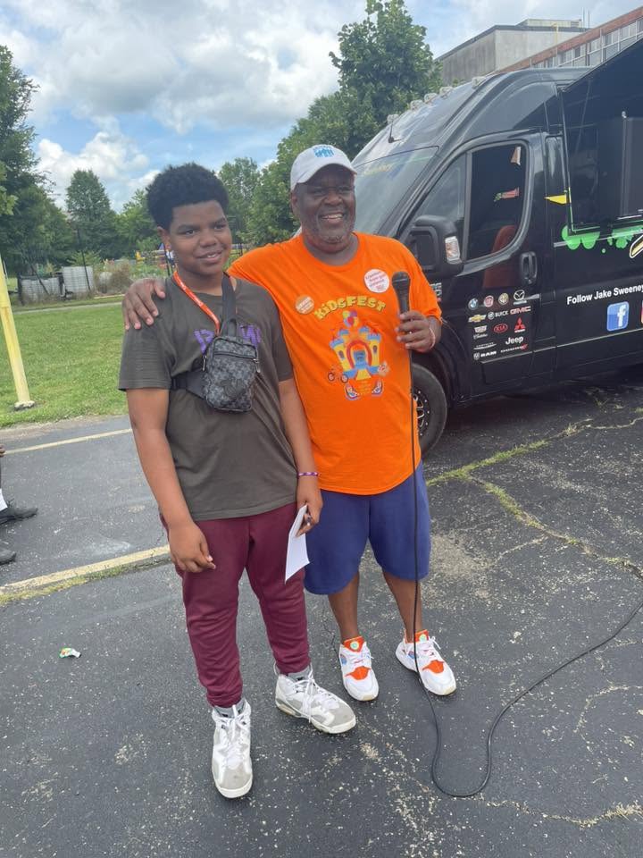 Brothas Inc. founder on the microphone with a young student at 3rd KidsFest