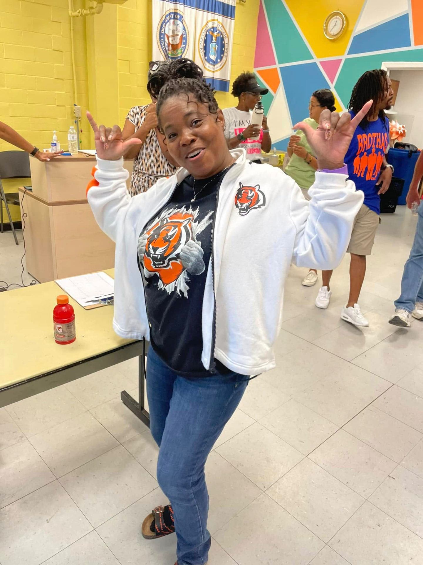 Volunteer in a Bengals jacket smiling and posing at the 2024 Backpack Giveaway
