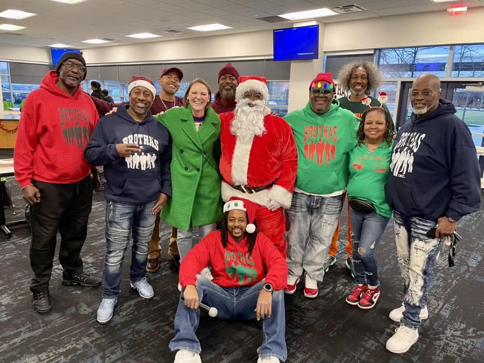Brothas Inc. mentors gathered around Santa in festive hoodies at Jingle Jam 2024