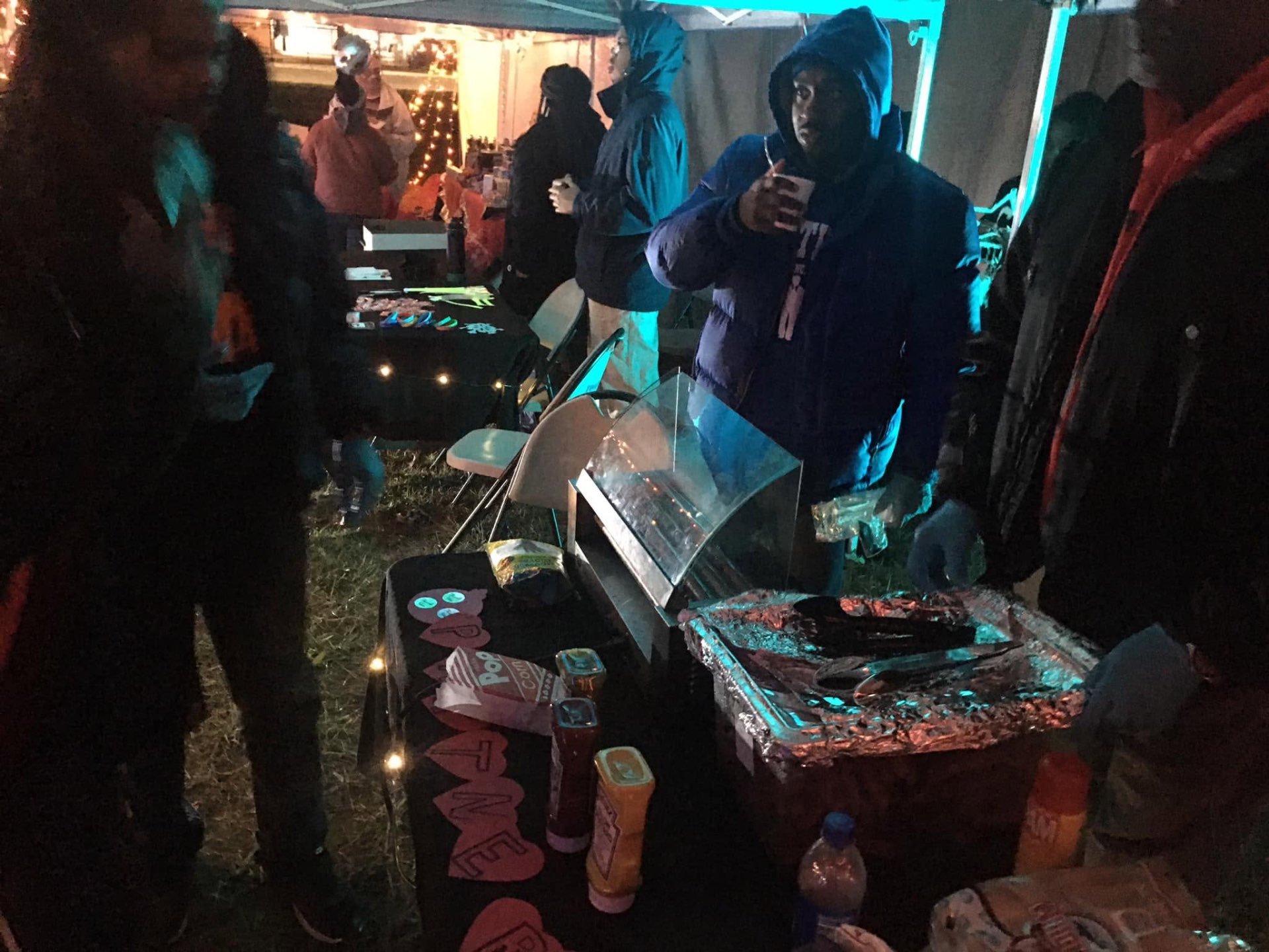 Volunteers serving hot popcorn and snacks under the tent at Brothas Inc. Jingle Jam 2023