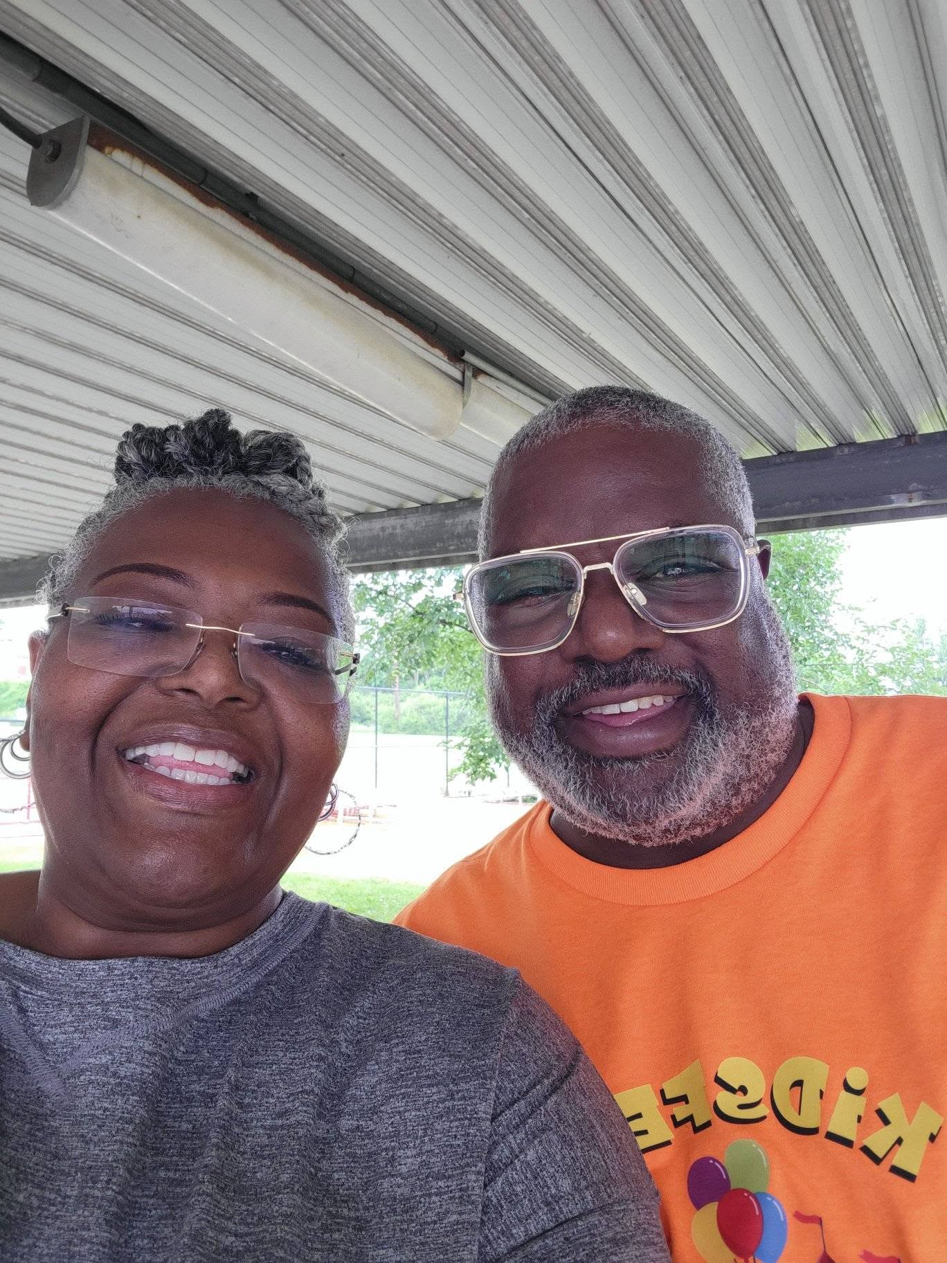 Close-up selfie of two Brothas Inc. supporters smiling under the pavilion at 3rd KidsFest