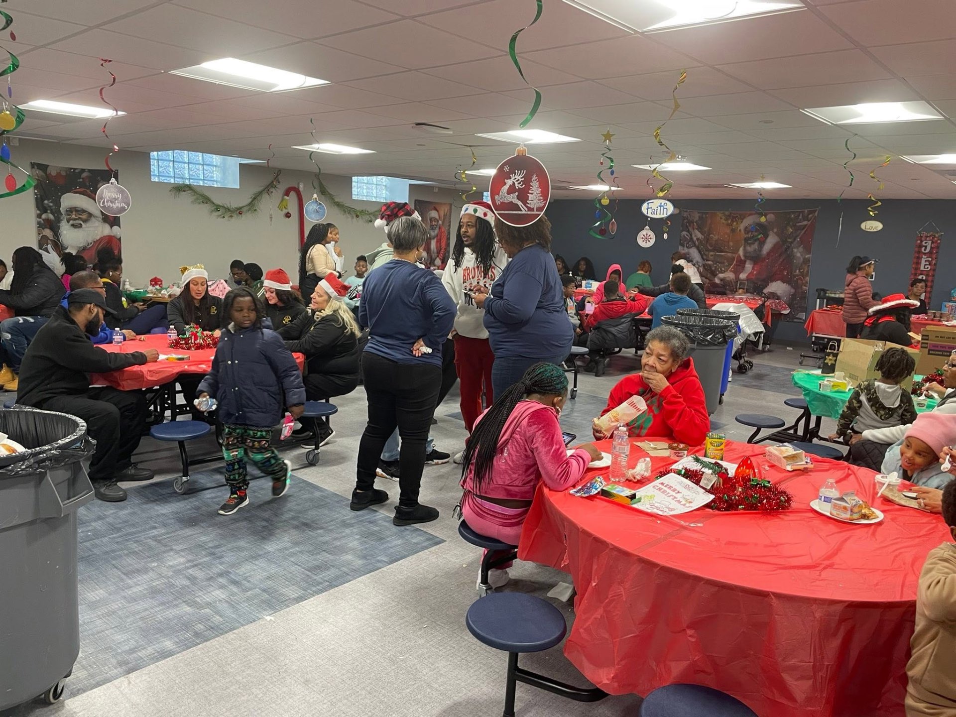 Packed cafeteria of families and volunteers enjoying food and fellowship at Brothas Inc. Jingle Jam 2025