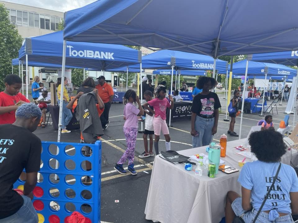 Kids playing life-sized Connect Four beside the ToolBank tents at 3rd KidsFest